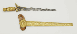 A Keris blade and sheath with a matching intricate floral design in gold.